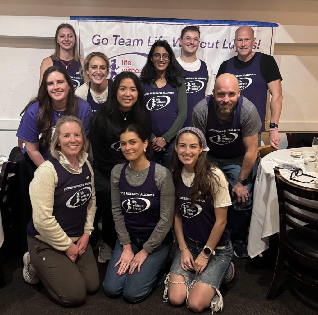 Group of runners pose with a "Team Life Without Lupus" banner